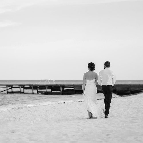 Black and white of bride + groom walking on beach at Azul Fives Hotel, Riviera Maya