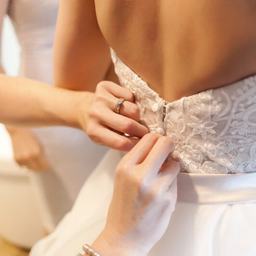 Close up of brides dress being done up