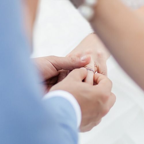 Close up of groom putting on ring