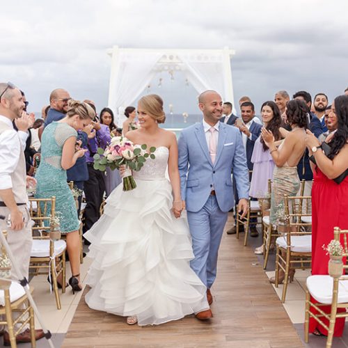 Bride and groom walking down aisle after wedding on sky deck at Azul Fives Hotel