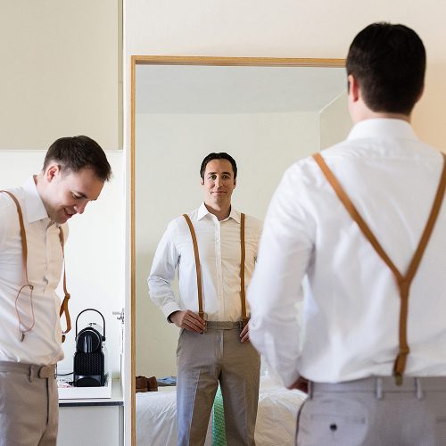 Groomsman looking in mirror getting ready at Finest Playa Mujeres Resort