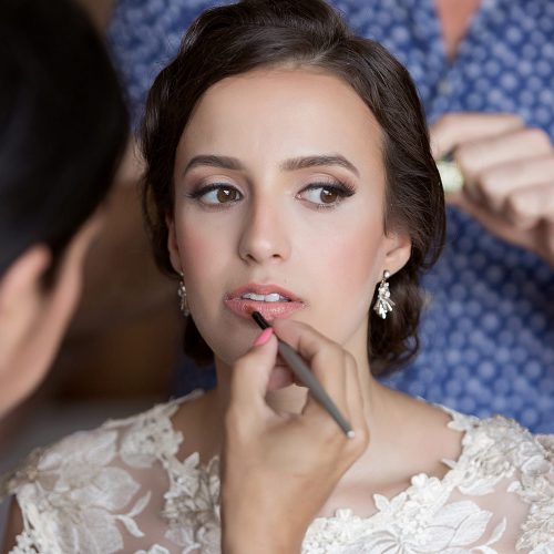 Bride getting final touches of makeup at wedding in Tulum.