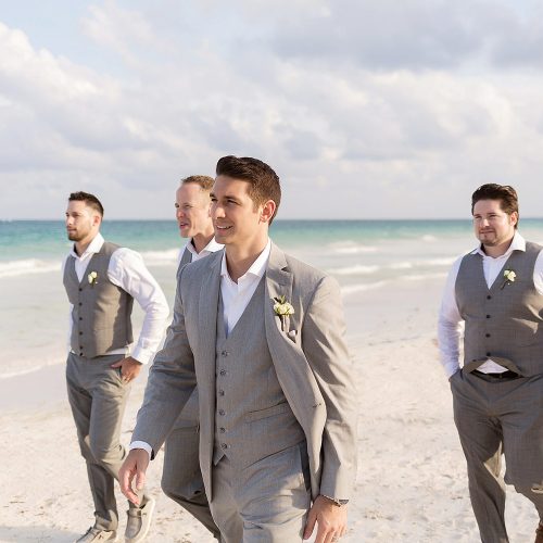Groomsmen walking on beach in Tulum