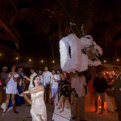Bride hitting piñata at wedding in Tulum