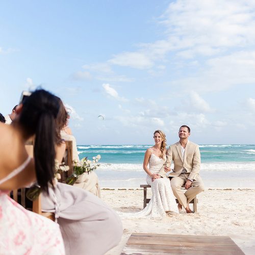 Bride and groom on bench at wedding ceremony at Akiin Tulum