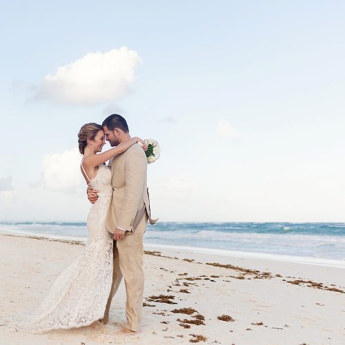 Bride and groom kissing on beach in Tulum.