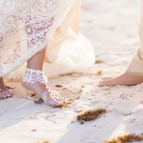 Close up of brides feet on beach in Tulum