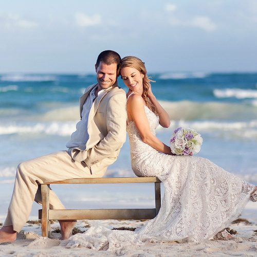 Bride and groom on bench in Tulum
