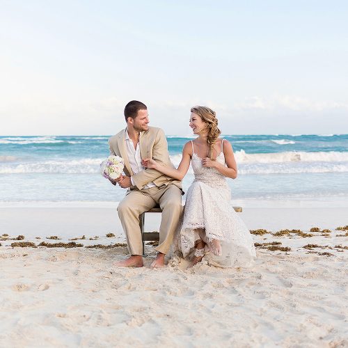 Bride and groom having fun on bench an beach in Tulum