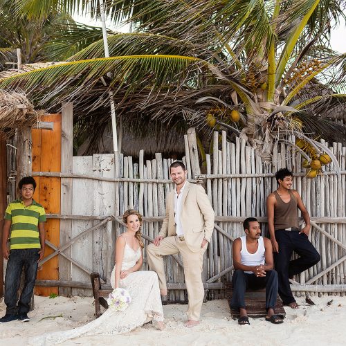Portait of bride with locals on beach in Tulum