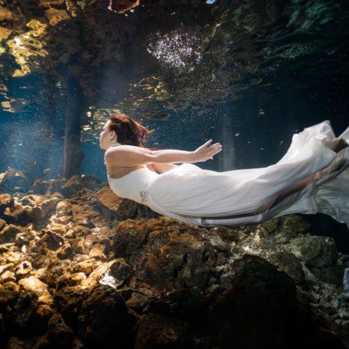 Bride swimming in underwater trash the dress in Mayan Cenote at Riviera Maya