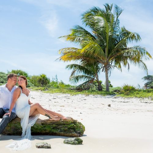 Bride and groom posing for trash the dress photo shoot at Riviera Maya beach
