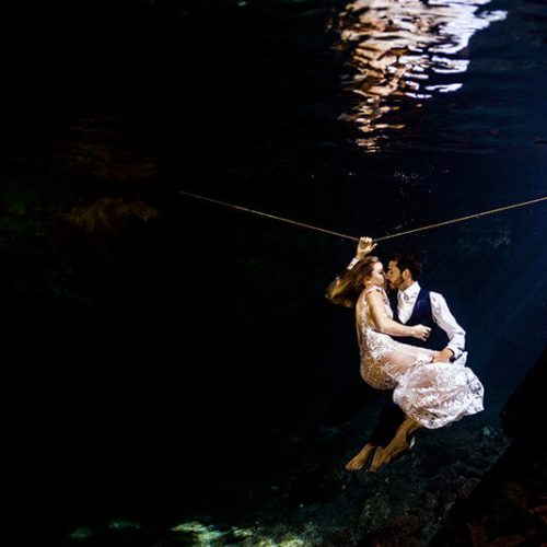 Couple holding in trash the dress photo shoot in Maya Cenote