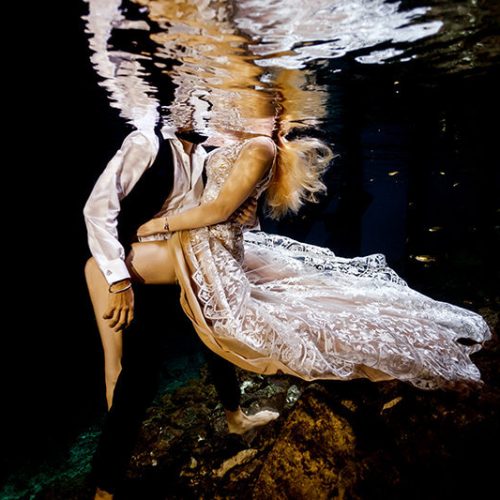 Sexy couple posing in underwater trash the dress in Maya Cenote