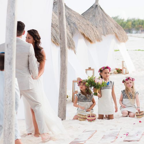 Flower girls watching ceremony at beach wedding