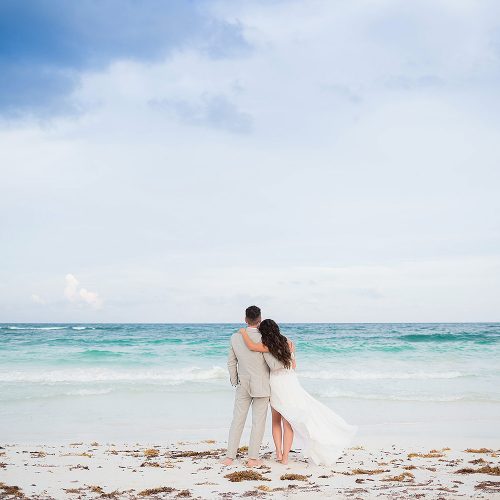 Bride and groom looking at sea in Riviera Maya
