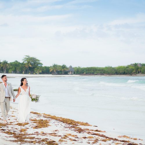 Bride and groom walking on beach in Riviera Maya