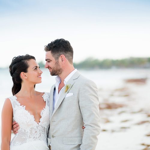 Bride and groom looking at each other on beach in Riviera Maya