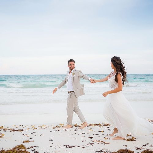 Bride and groom having fun on beach after wedding in Riviera Maya