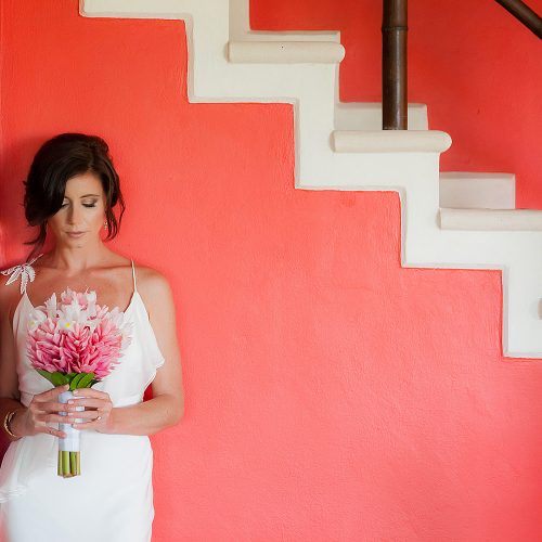 Portrait of bride near stairs before wedding ceremony.