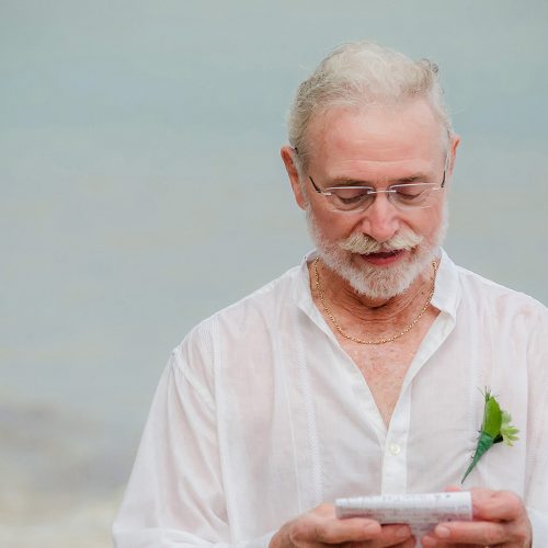 Father giving reading in the rain at wedding in Tulum