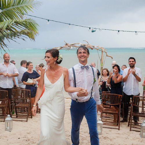 Bride and groom celebrate after wedding ceremony in the rain in Tulum