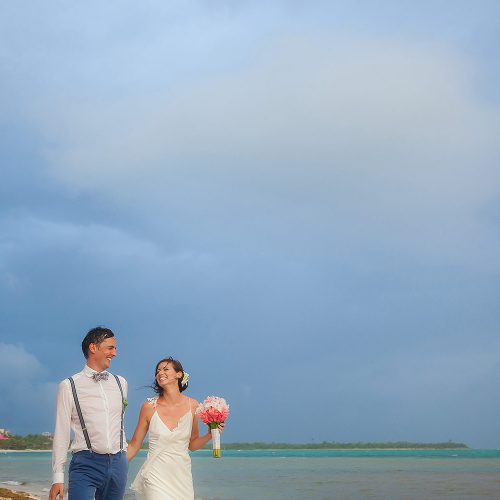 Bride and groom walking on beach in tulum