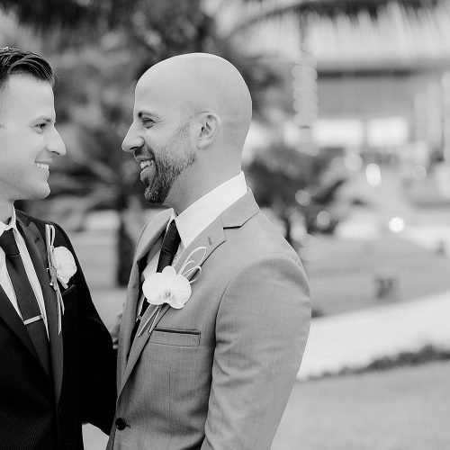Groomsmen looking at each other at gay wedding