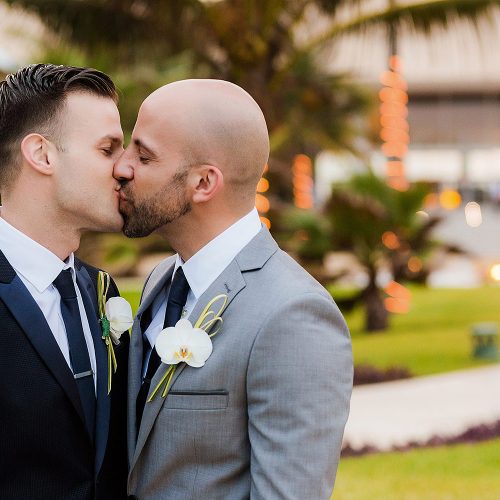 Grooms kissing after gay wedding