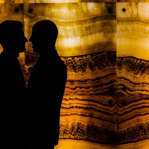Silhouette photograph of grooms in lobby at NOW Jade Riviera Cancun resort.