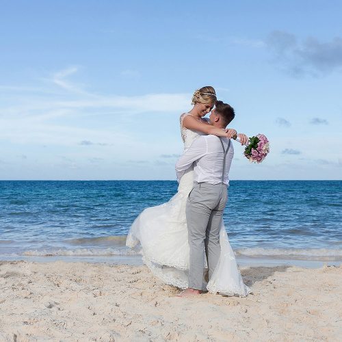 Bride and groom having fun on beach in Cancun
