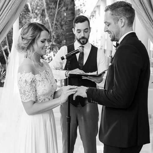 Bride putting on grooms ring at Cancun wedding