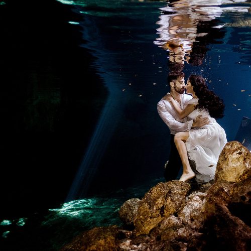 Bride and Groom underwater in wedding outfits at Trash the Dress in Riviera Maya Mexico