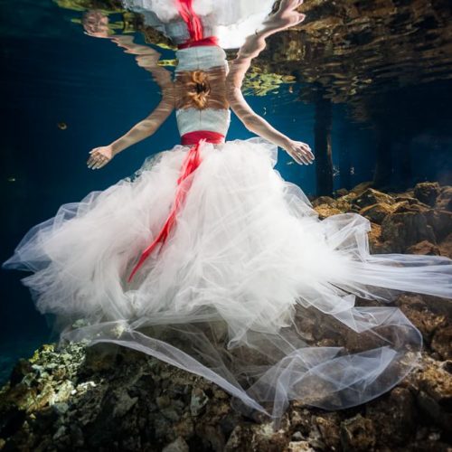 Back of dress with bride underwater in cenote in Meico