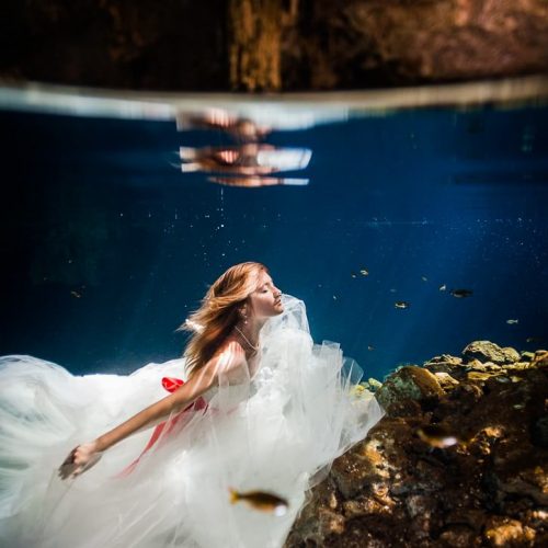 Bride underwater in wedding dress in Riviera Maya