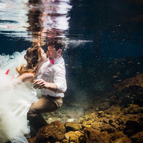 Bride underwater in wedding dress in Mayan Cenote Mexico