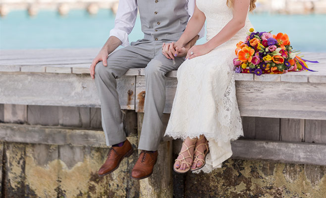 Bride and Grooms feet hanging of dock at wedding in Cancun