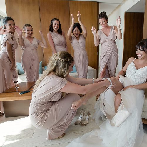 Bridesmaid putting on garter before wedding