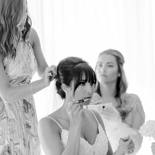Bride doing last touches to makeup.
