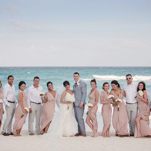 Bride, groom and wedding party on beach in Cancun.