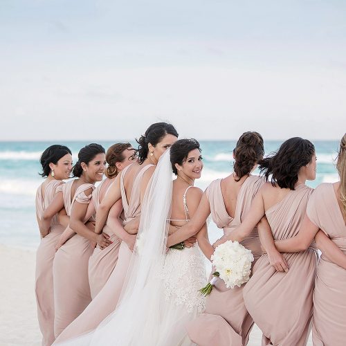 Bride with bridesmaids on beach in Cancun