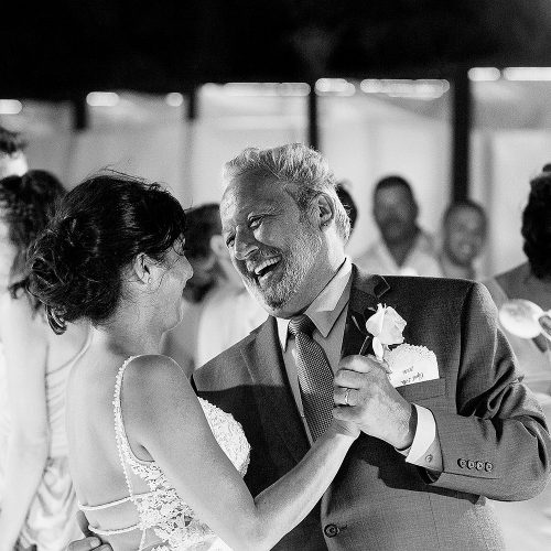 Bride and father laughing during father daughter dance.