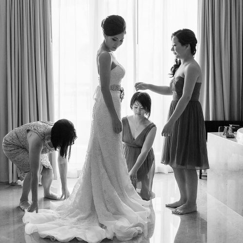 Bridesmaids helping bride with dress at Moon Palace Cancun