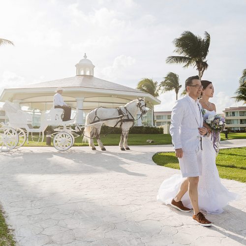 Bride walking away with horse and carriage in background at Moon Palace Cancun