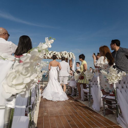 Bride walking down aisle on beach at Moon Palace Cancun