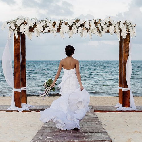 Bride running down beach at Moon Palace Cancun