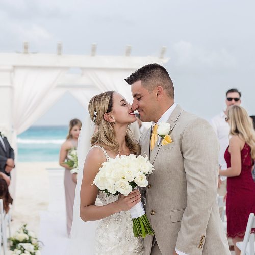 Bride and groom kissing after wedding ceremony on beach in Cancun
