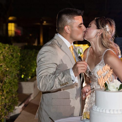 Bride and groom kissing after cutting wedding cake