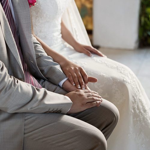 Close up of bride and groom holding hands at wedding ceremony in Riviera Maya