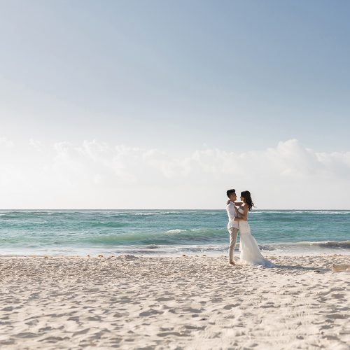 Bride and groom kissing on beach in Riveira Maya Mexico